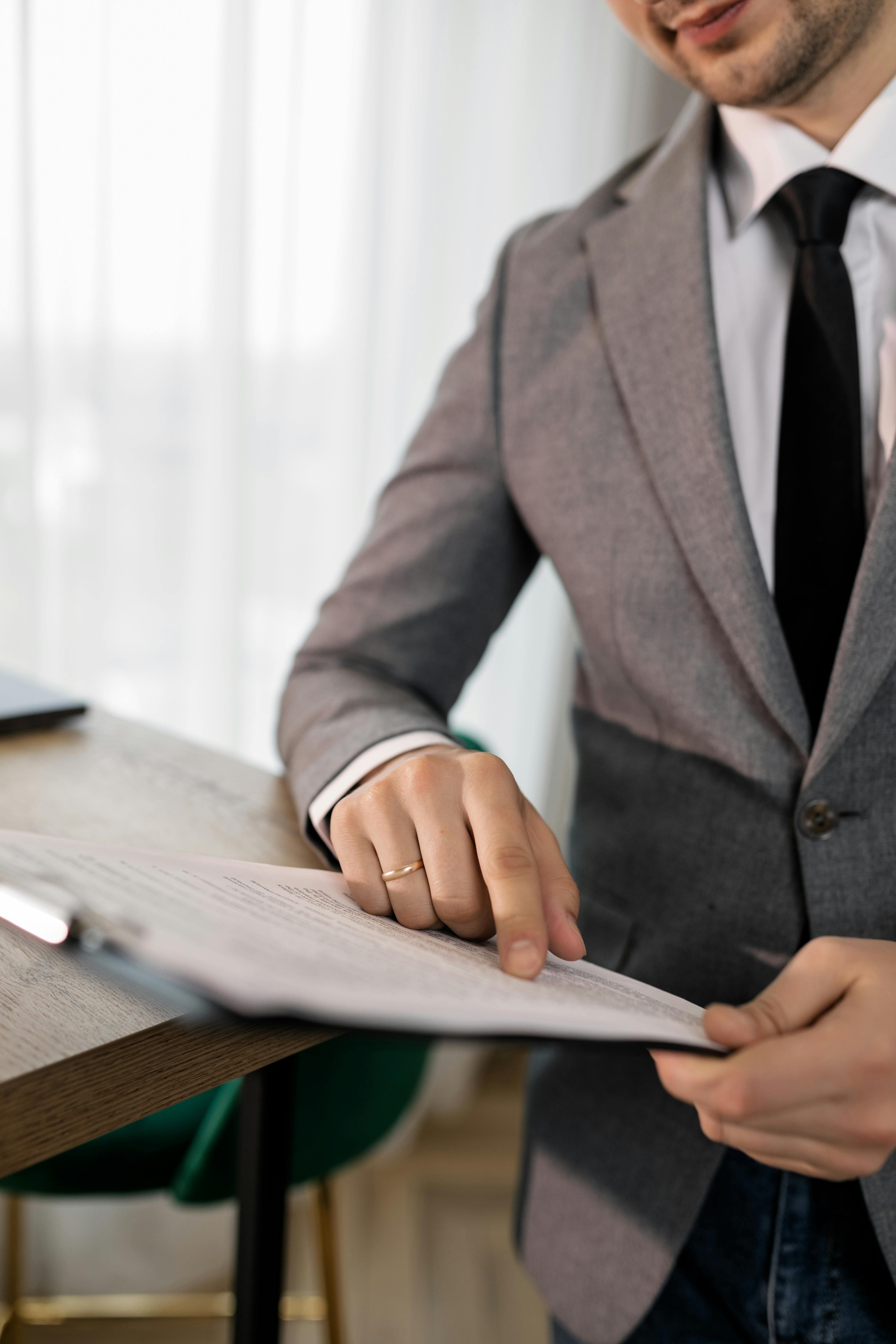 A man in a suit holding a piece of paper